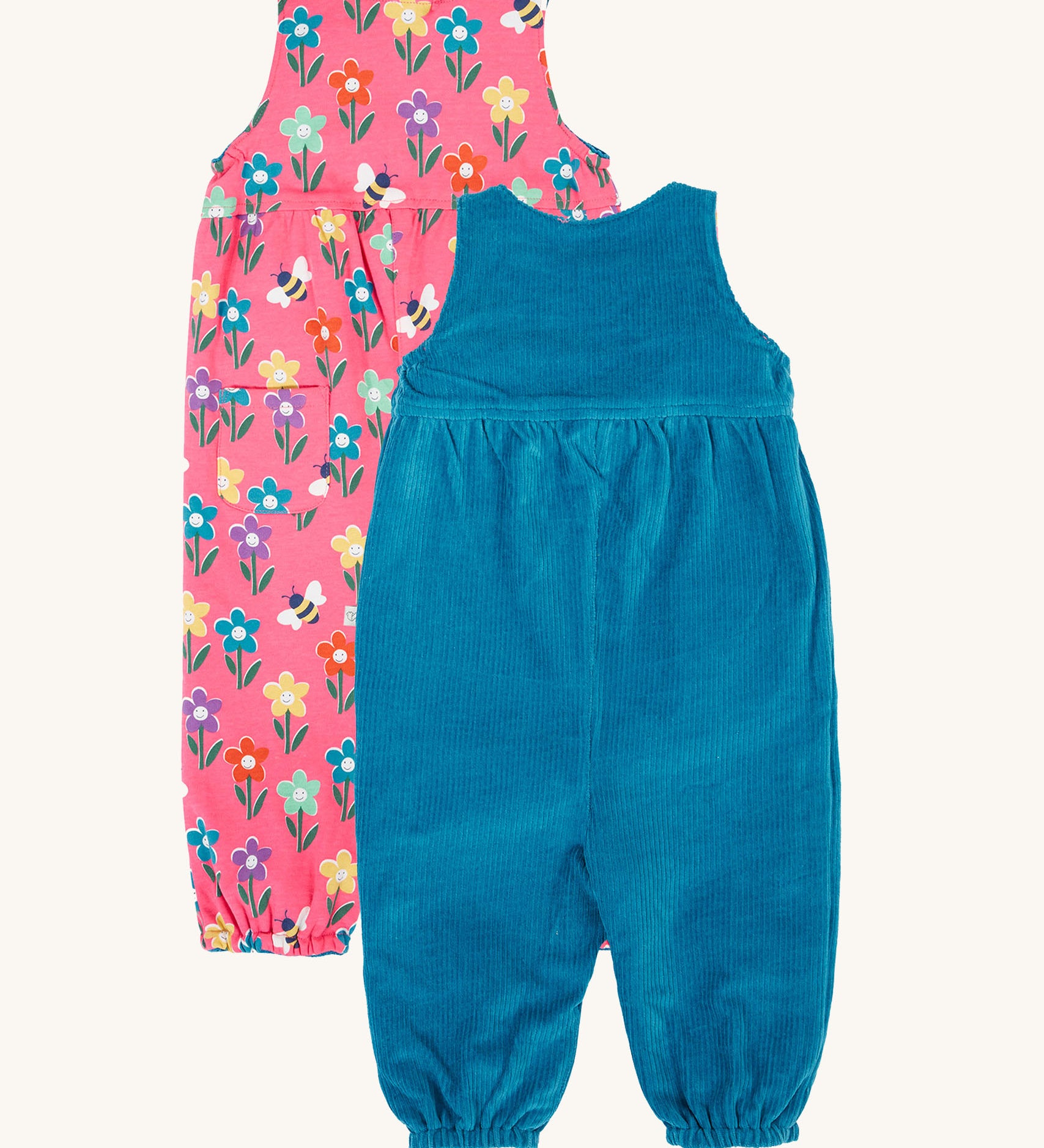 Frugi kids reversible helen dungarees in boat blue/fun flowers. A 100% GOTS organic cotton dungaree with a blue corduroy a pink reversible side with playful flower prints and handy back pocket. Features popper fasteners on the shoulder straps and cuffed  ankles.