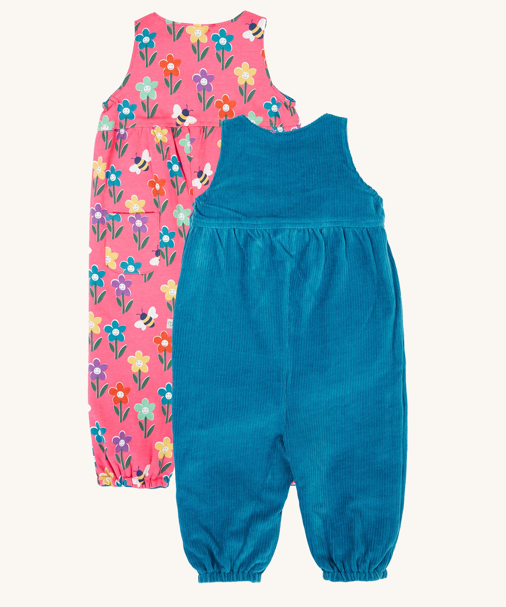 Frugi kids reversible helen dungarees in boat blue/fun flowers. A 100% GOTS organic cotton dungaree with a blue corduroy a pink reversible side with playful flower prints and handy back pocket. Features popper fasteners on the shoulder straps and cuffed  ankles.