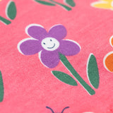 A close up of the Frugi kids reversible helen dungarees in playful flowers. showing the playful flower print detail  on pink organic cotton fabric.