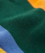 A close up of the penguin/ rainbow Frugi reversible voyager hat showing the bold striped design on GOTS organic cotton fabric.