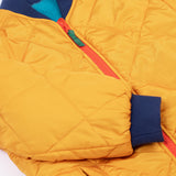 A close up of the navy cuffed sleeves on the Frugi robin reversible quilted jacket in yellow gold with boat blue fleece.