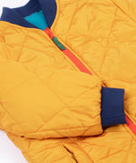 A close up of the navy cuffed sleeves on the Frugi robin reversible quilted jacket in yellow gold with boat blue fleece.