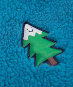 A super close up detail shot of the tree badge that is on the chest of the blue fleece side of the frugi robin-quilted-lined-reversible-jacket-yellow-gold