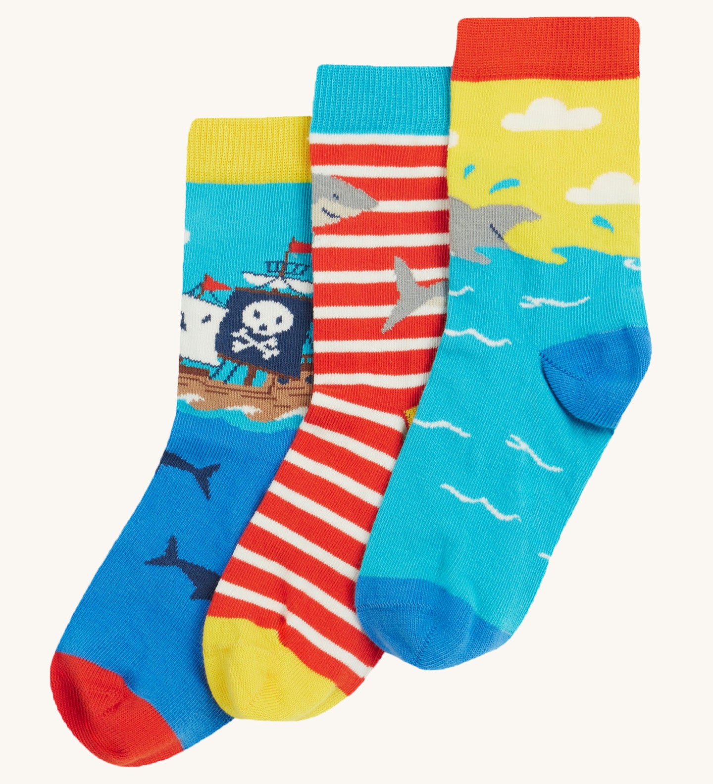 Frugi Rock My Socks 3 Pack laid flat, in the High Seas print. Featuring a bright striped pair, a blue pirate ship pair, and a brilliant shark pair.