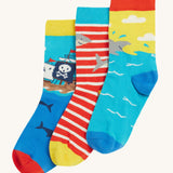 Frugi Rock My Socks 3 Pack laid flat, in the High Seas print. Featuring a bright striped pair, a blue pirate ship pair, and a brilliant shark pair.