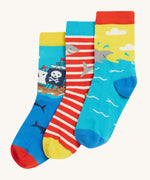 Frugi Rock My Socks 3 Pack laid flat, in the High Seas print. Featuring a bright striped pair, a blue pirate ship pair, and a brilliant shark pair.