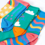 Close up of the Frugi little roly bamboo socks in a 3 pack with rainbow designs. Rainbow wave stripe pair, green with happy rainbow pair and a patchwork pattern pair.