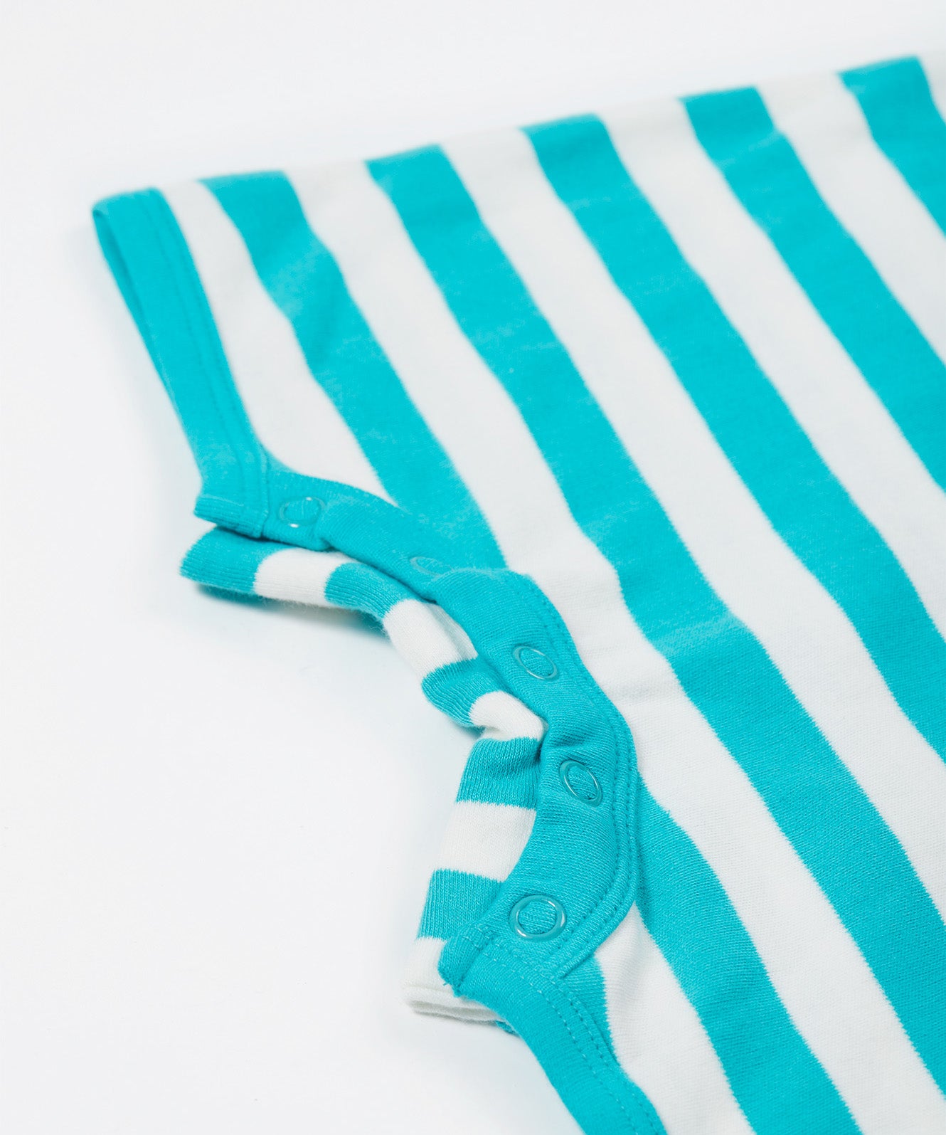 A close up of the Frugi Koala rue romper showing the detail of the popper fastners by the leg cuffs on blue and white striped organic cotton fabric
