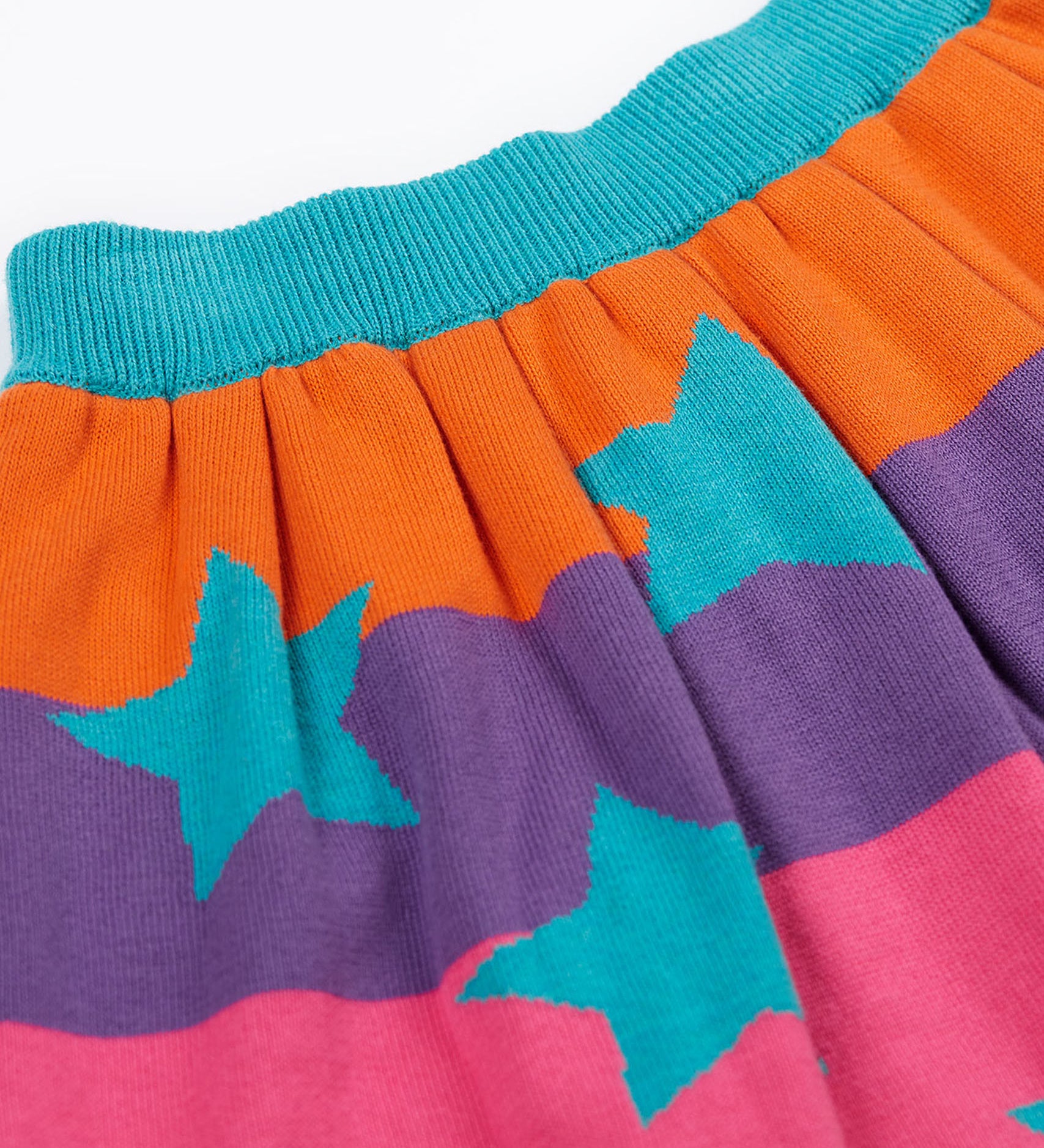 A close up of the Frugi Rory Reversible organic cotton kids Skirt with a Rainbow Stars design.
