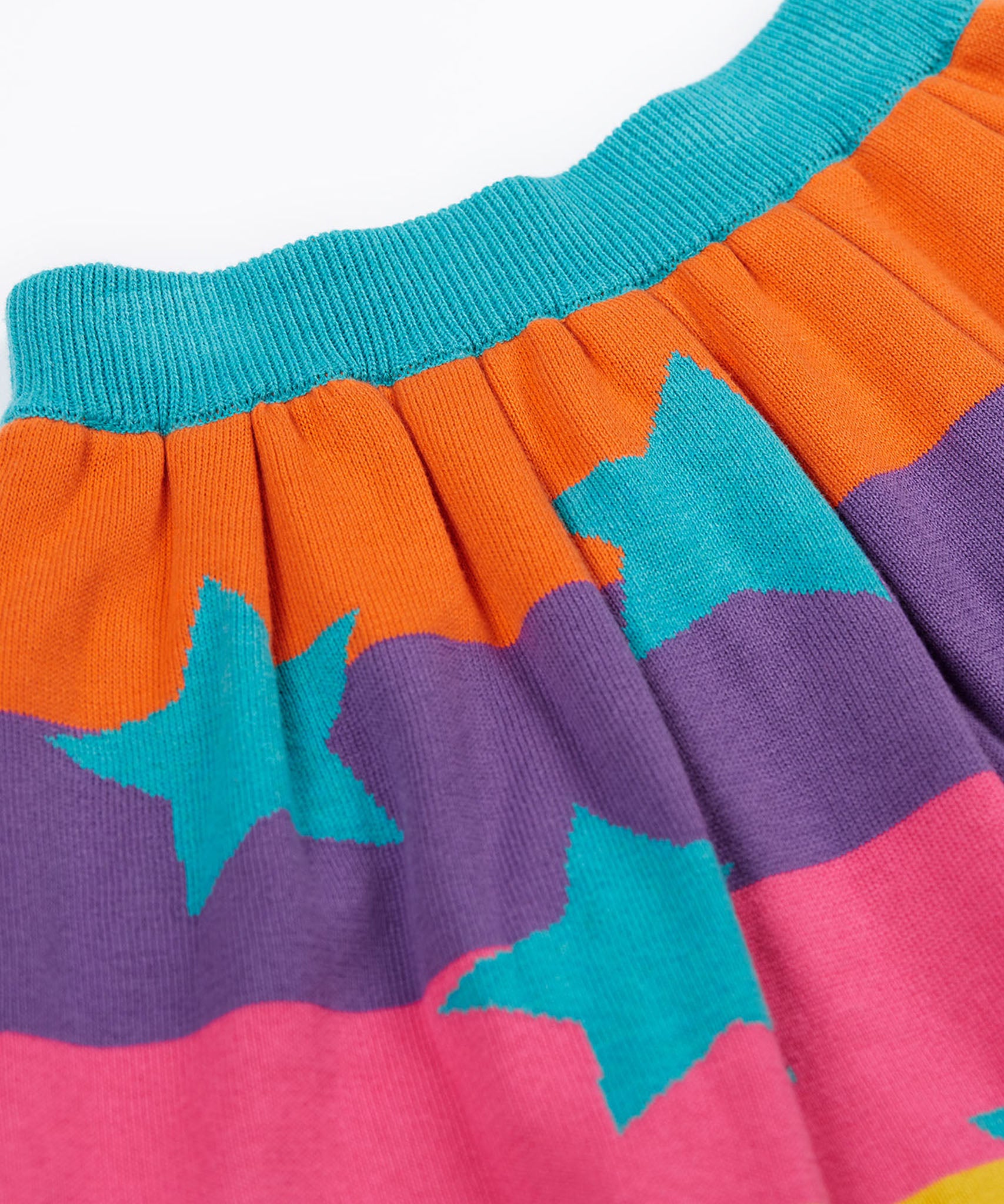 A close up of the Frugi Rory Reversible organic cotton kids Skirt with a Rainbow Stars design.