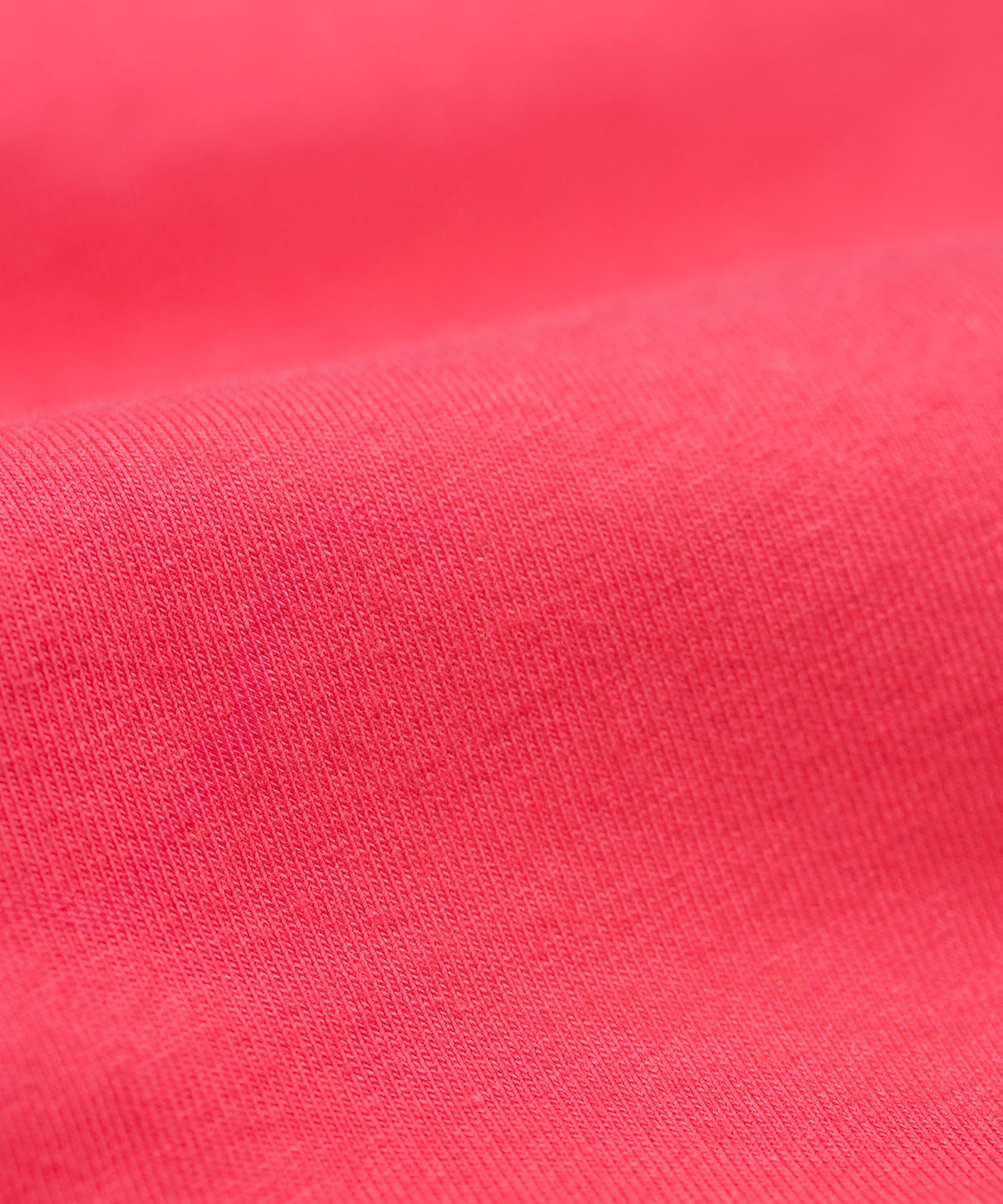 A close up of the Frugi kids libby leggings in rose showing the knit detail on bright pink organic cotton fabric.
