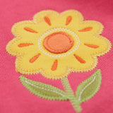 A close up of the yellow flower applique on the knee of the Frugi rose pink coloured flower and mushroom crawlers kids joggers.