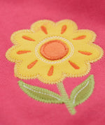 A close up of the yellow flower applique on the knee of the Frugi rose pink coloured flower and mushroom crawlers kids joggers.