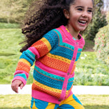 A child running in a park and wearing the Frugi kids rowe rainbow cardigan in rainbow/pointelle.