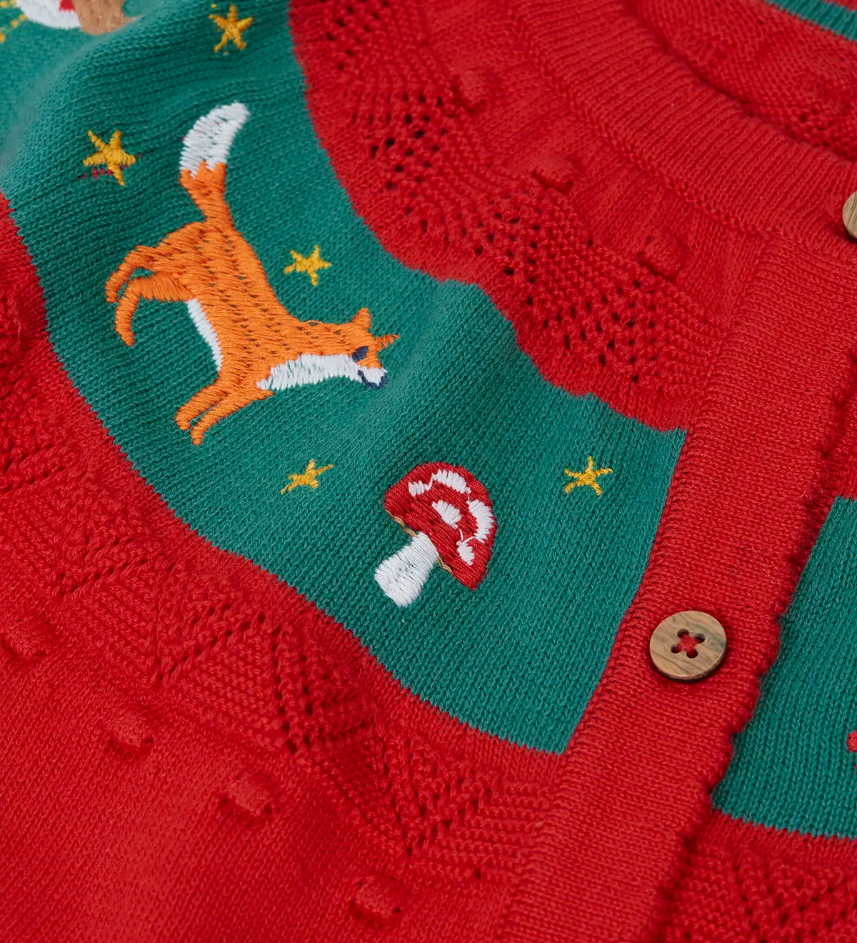 Close up of the embroidered fox and toadstool on the Frugi scarlet red organic cotton ishbel embroidered fox cardigan.