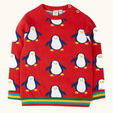 Frugi scarlet penguins organic cotton jolly knitted jumper. Red knitted jumper with repeat penguin print and rainbow stripe hemline and arm cuffs.