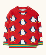 Frugi scarlet penguins organic cotton jolly knitted jumper. Red knitted jumper with repeat penguin print and rainbow stripe hemline and arm cuffs.