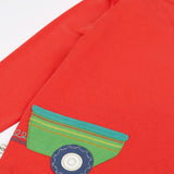 Back of Frugi 'sGOTS organic cotton red long sleeve top showing a green trailer applique.