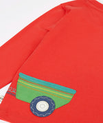 Back of Frugi 'sGOTS organic cotton red long sleeve top showing a green trailer applique.
