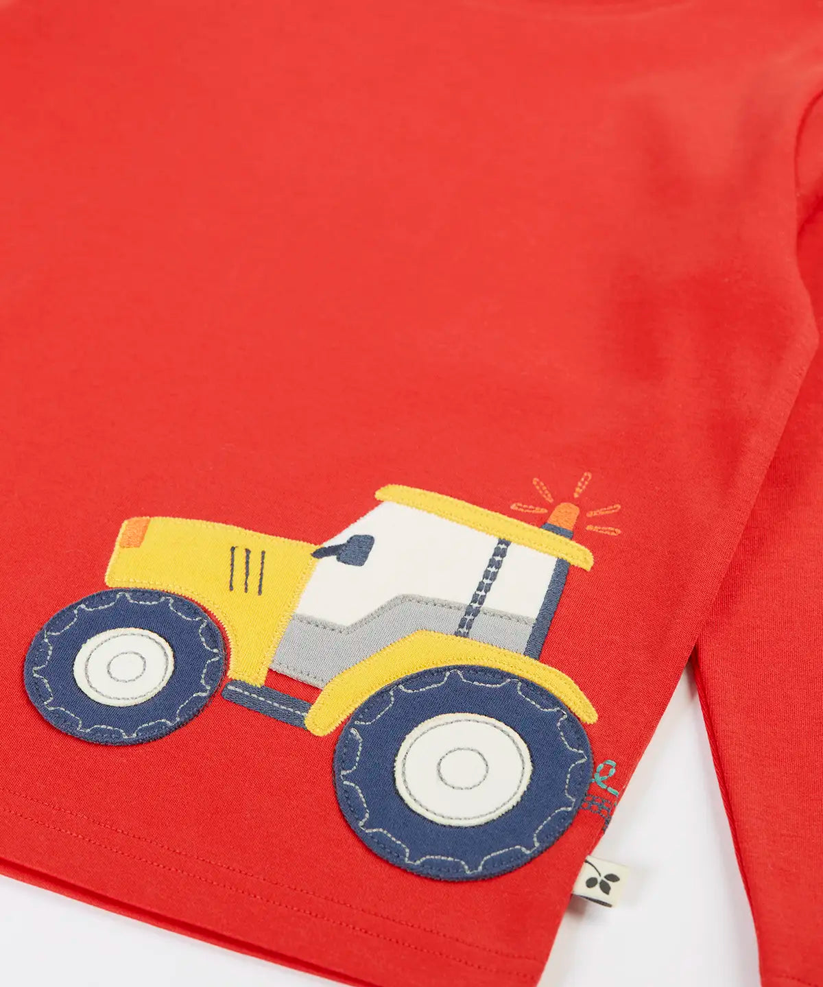 Frugi GOTS organic cotton red long sleeve top showing a yellow tractor applique on the bottom 