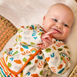 Baby wearing the striped babygrow and wild cats cardigan from the Frugi scrumptious babygrow gift set.