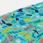 A close up of the Frugi Maris Playsuit, with a Sea Life print which includes different sea animals and colourful seaweed and coral, featuring a small pocket.