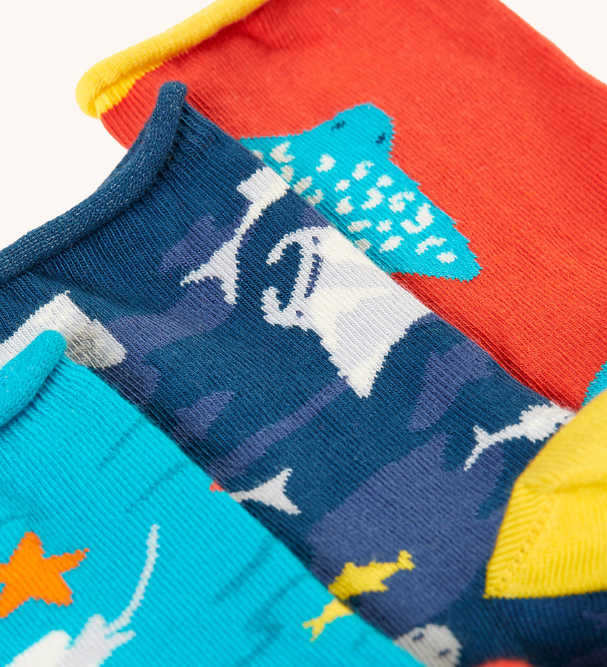 A close up of the roll tops on the Frugi pack of three sealife themed bamboo children's socks. A looser fit roll top for comfort.