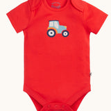 The red vest with blue tractor on from the A two pack of Frugi short sleeve baby vests. 