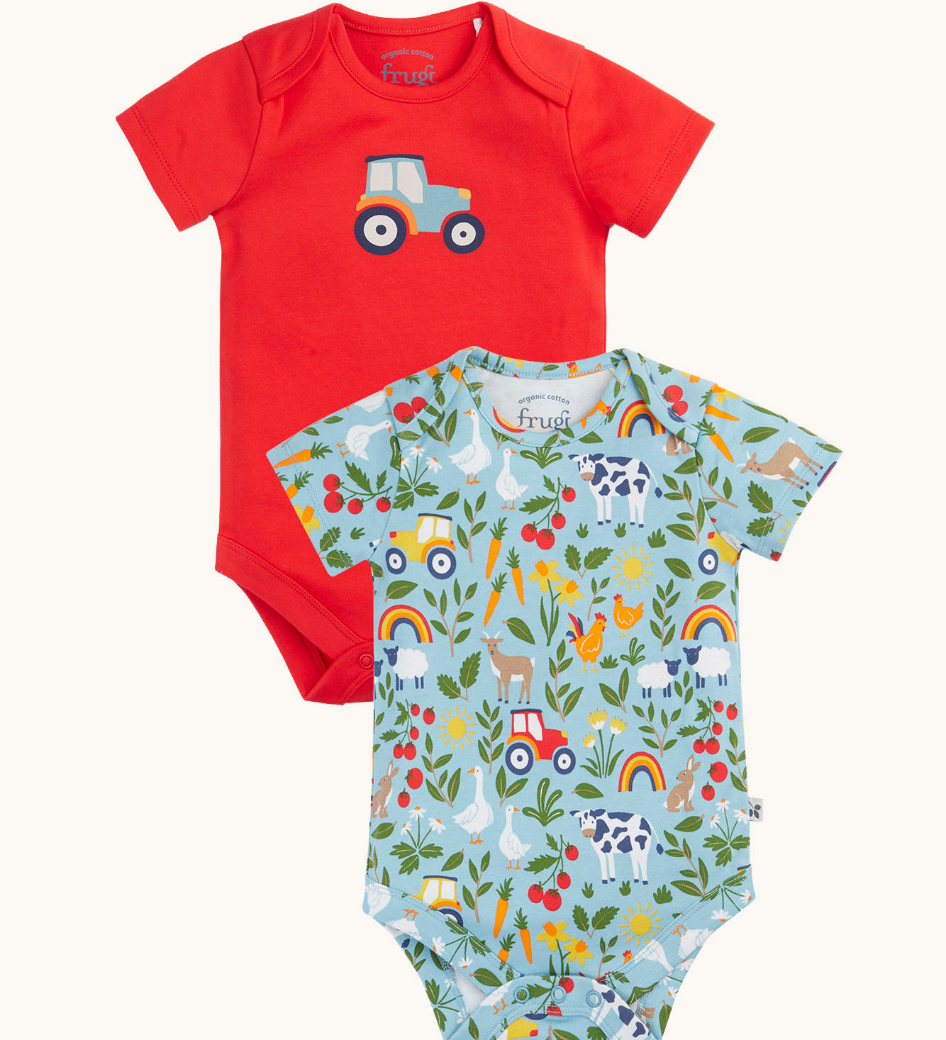A two pack of Frugi short sleeve baby vests. One with a plain red background and a blue tractor printed on the front the other had a on the farm themed all over print featuring farm animals, tractors, leaves and plants on a light blue background.