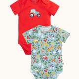 A two pack of Frugi short sleeve baby vests. One with a plain red background and a blue tractor printed on the front the other had a on the farm themed all over print featuring farm animals, tractors, leaves and plants on a light blue background.