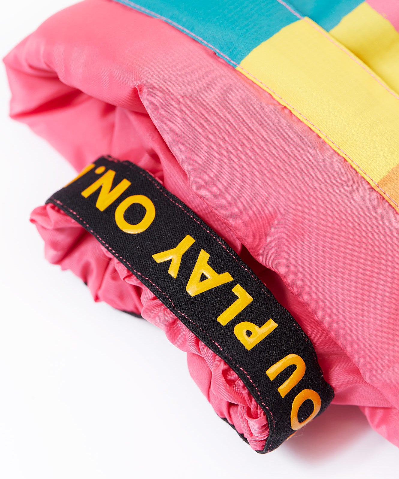 A close up of the Frugi rainbow check snow and ski salopettes showing the pink snow cuff detail 