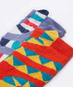 A close up of the Frugi kids character kids sock. Showing the ankle cuffs with the yellow snake and lemur tail on a orange and purple organic cotton fabric