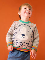 Child wearing the Frugi snow leopard organic cotton character knit jumper with 3d ears, green neck trim and rainbow arm cuffs and hemline. 