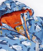 A close up of the Frugi kids snow and ski coat in penguin waddle showing the orange zip detail and matching fleece with the name tag patch stitched on the inside