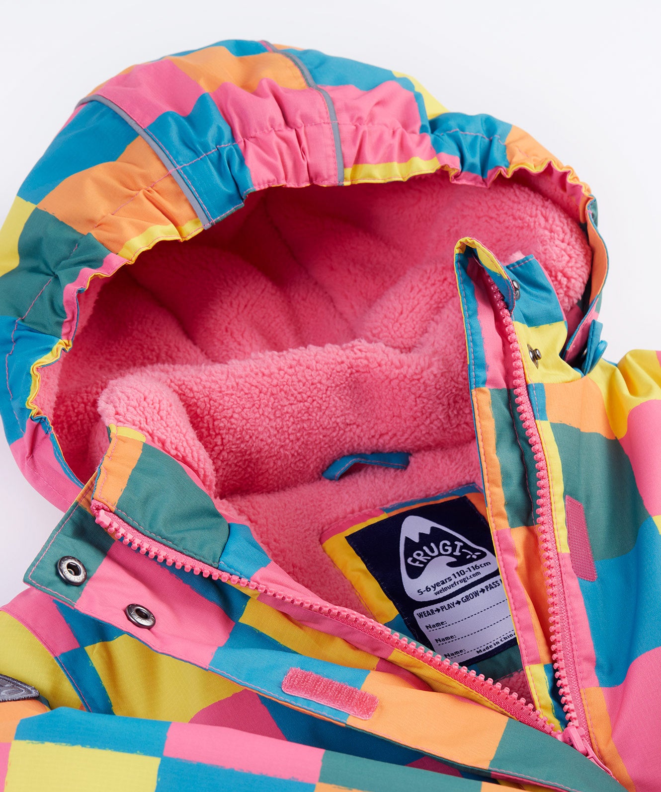 A close up of the Frugi kids snow and ski coat in rainbow check showing the pink zip detail and matching fleece with the name tag patch stitched on the inside