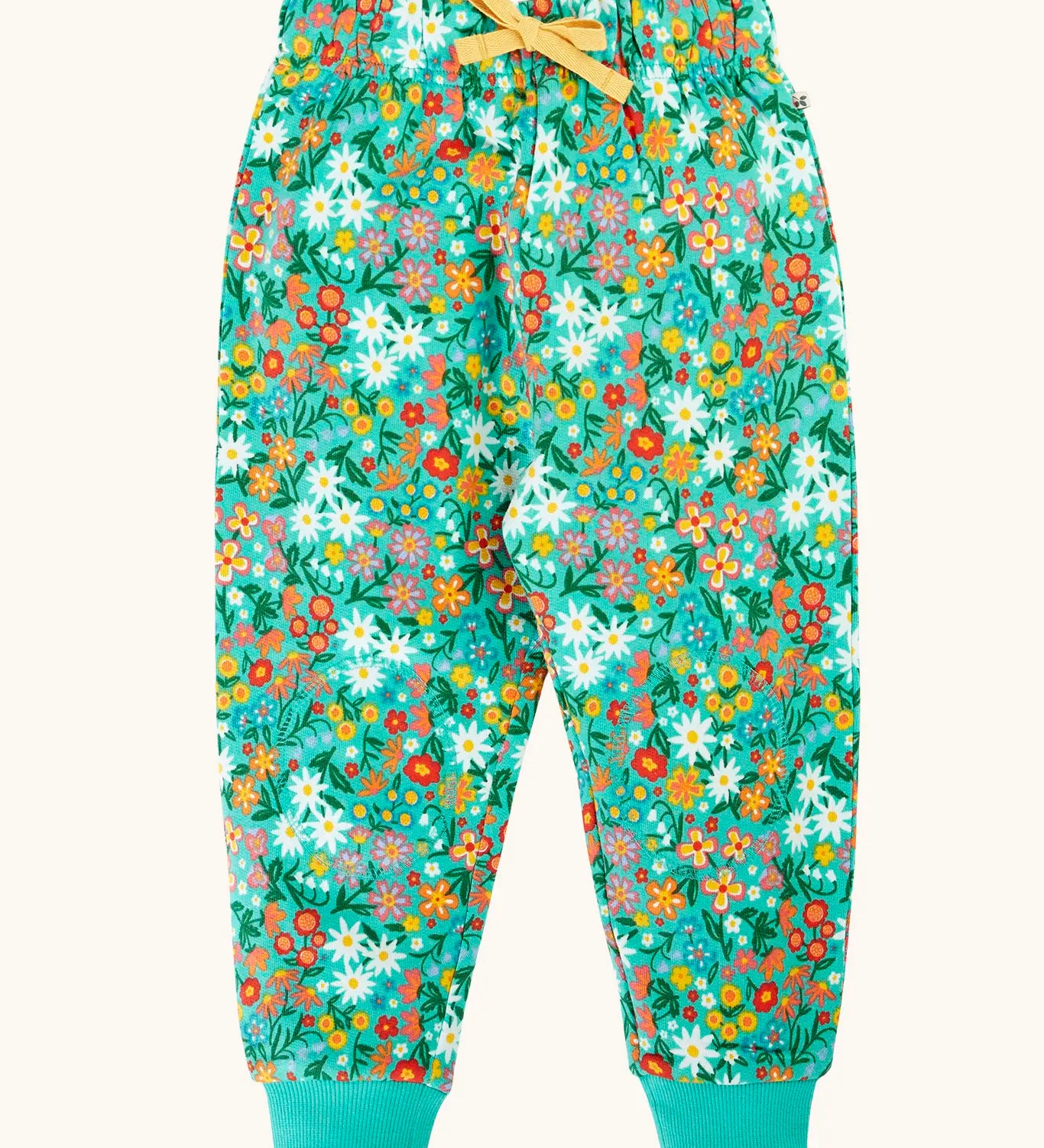 Frugi organic cotton kids snuggle joggers in green with an all over wildflower wander themed print.