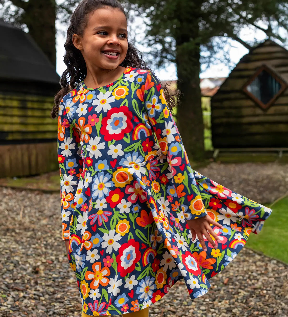 Girl wearing the Frugi Sofia organic cotton skater dress with a beautiful bunch all over flower print. 