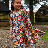 Girl wearing the Frugi Sofia organic cotton skater dress with a beautiful bunch all over flower print. 