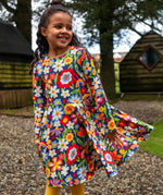 Girl wearing the Frugi Sofia organic cotton skater dress with a beautiful bunch all over flower print. 