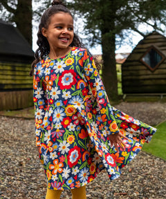 Girl wearing the Frugi Sofia organic cotton skater dress with a beautiful bunch all over flower print. 