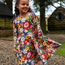 Girl wearing the Frugi Sofia organic cotton skater dress with a beautiful bunch all over flower print. 