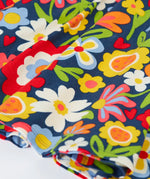 Close up of the hemline on the Frugi Sofia organic cotton skater dress with a beautiful bunch all over flower print. 