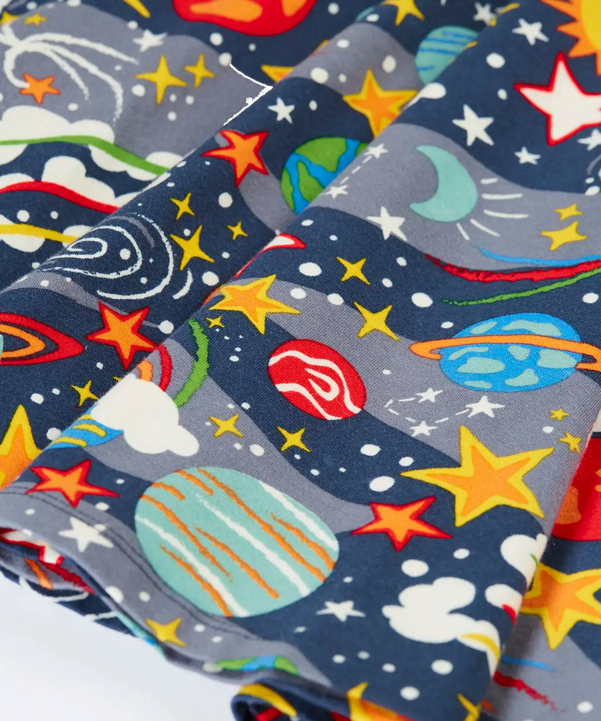 Close up of the skirt on the Frugi Sofia organic cotton skater dress in navy with an all over explore the stars print. 
