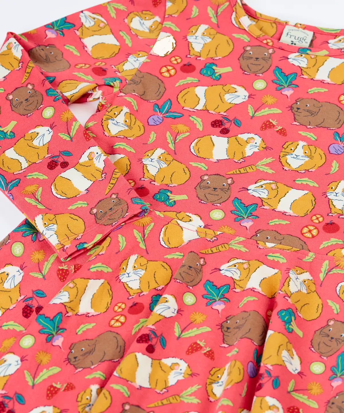 Close up of the Frugi Sofia skater dress in pink with an all over guinea pig muddle print. 