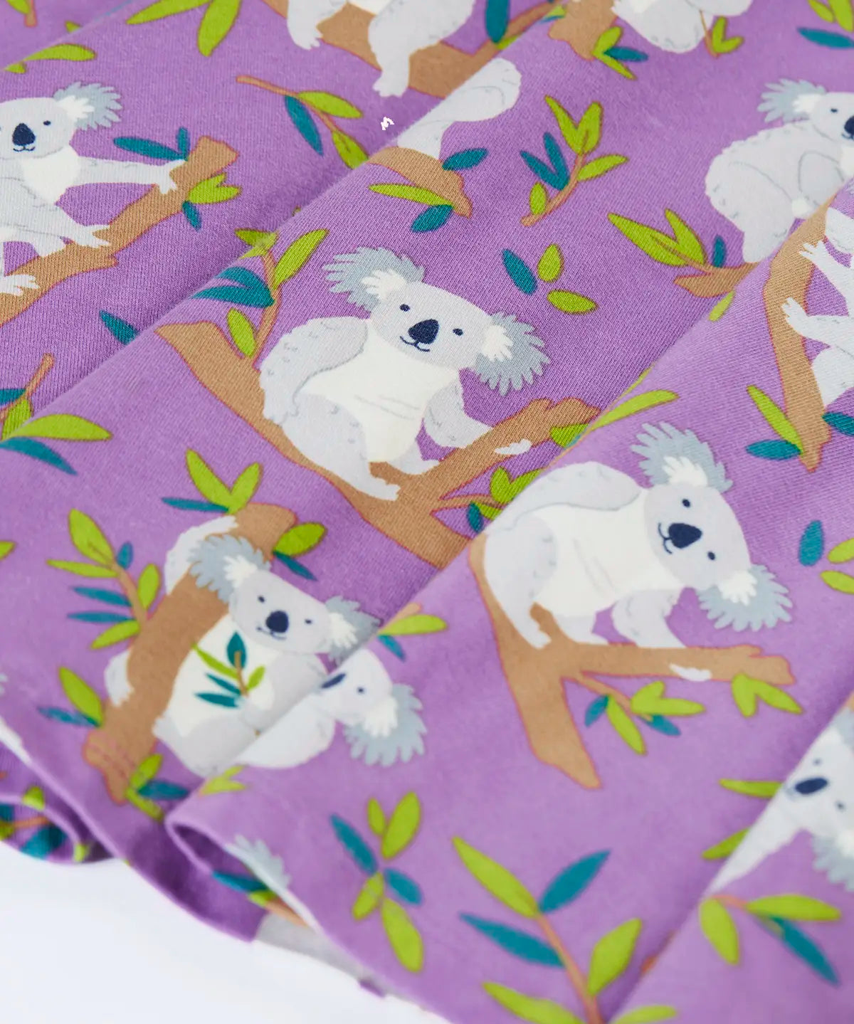 Close up of the skirt on the Frugi Sofia organic cotton skater dress in purple with an all over koala cuddles print.