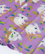 Close up of the skirt on the Frugi Sofia organic cotton skater dress in purple with an all over koala cuddles print.