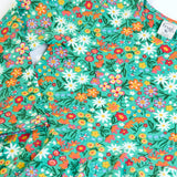 Close up of the front of the Frugi Sofia organic cotton kids long sleeved skater dress in green with an all over wildflower wander print. 