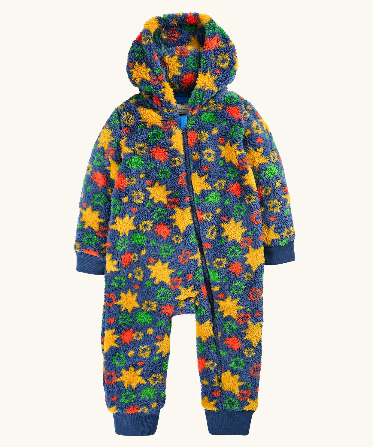 A frugi hooded one-piece baby jumpsuit in a fuzzy fleece material, featuring a vibrant multicolor star pattern on a navy blue base. The jumpsuit has a front zipper, ribbed cuffs, and ribbed ankle cuffs.