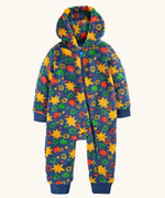 A frugi hooded one-piece baby jumpsuit in a fuzzy fleece material, featuring a vibrant multicolor star pattern on a navy blue base. The jumpsuit has a front zipper, ribbed cuffs, and ribbed ankle cuffs.