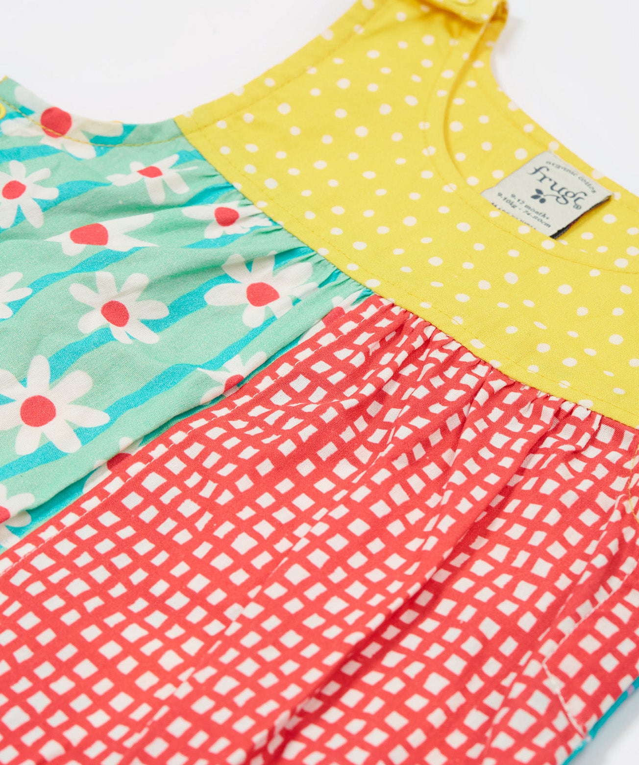 A close up of the front of the Frugi Summer Printed Dungaree in the Rainbow Hotchpotch print.